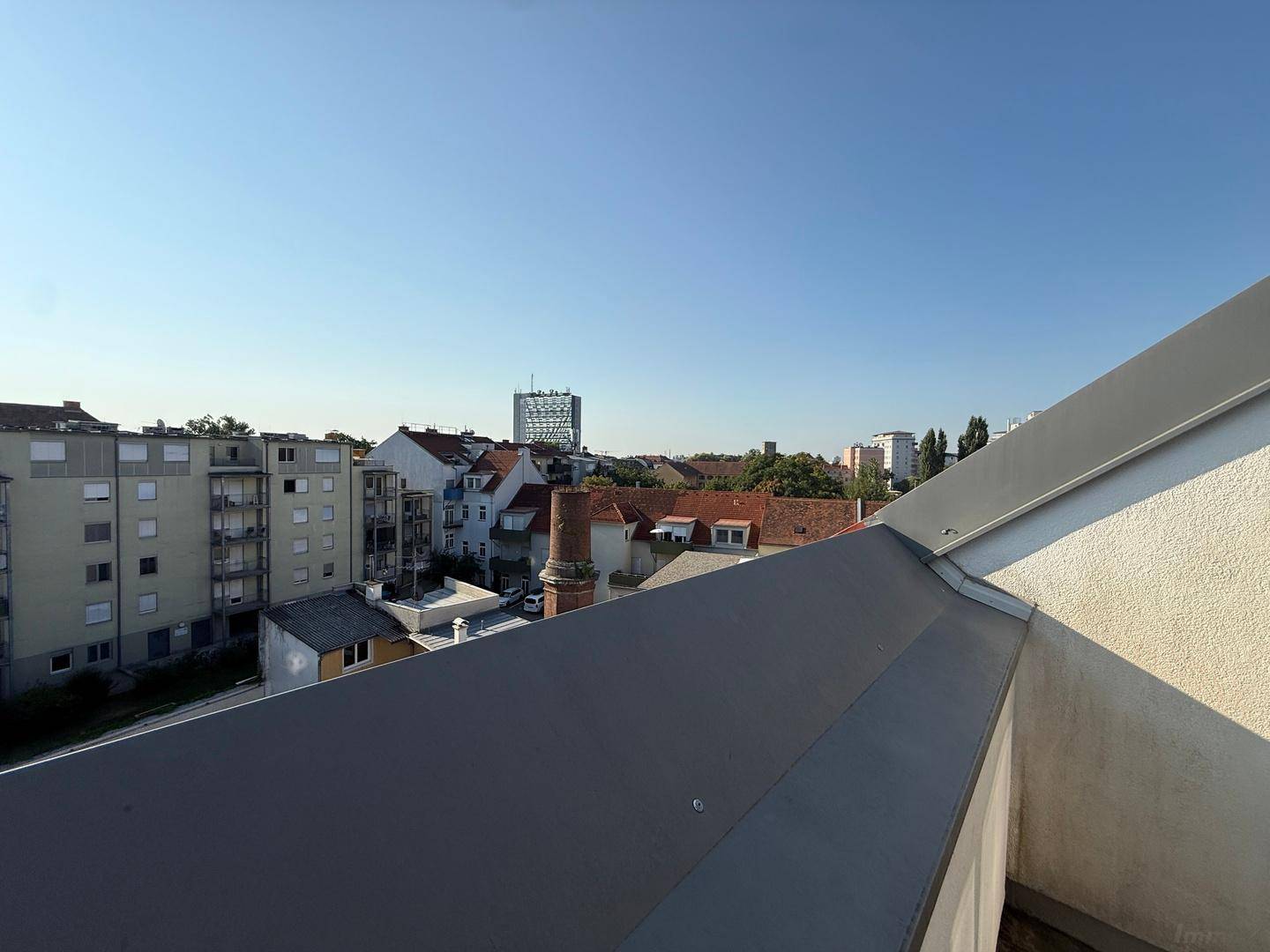 Weitläufiger Blick über die Dächer der Stadt und die umliegende Bebauung an einem klaren Tag.