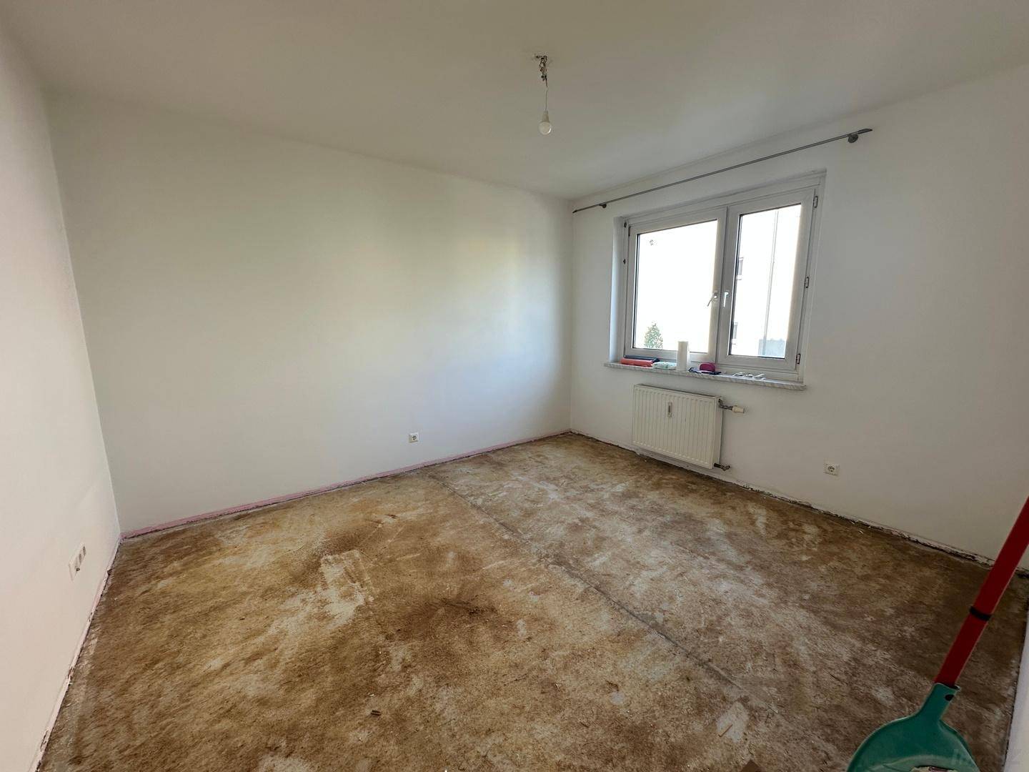 Geräumiges Zimmer mit viel Tageslicht und vorbereitetem Boden für die individuelle Einrichtung.