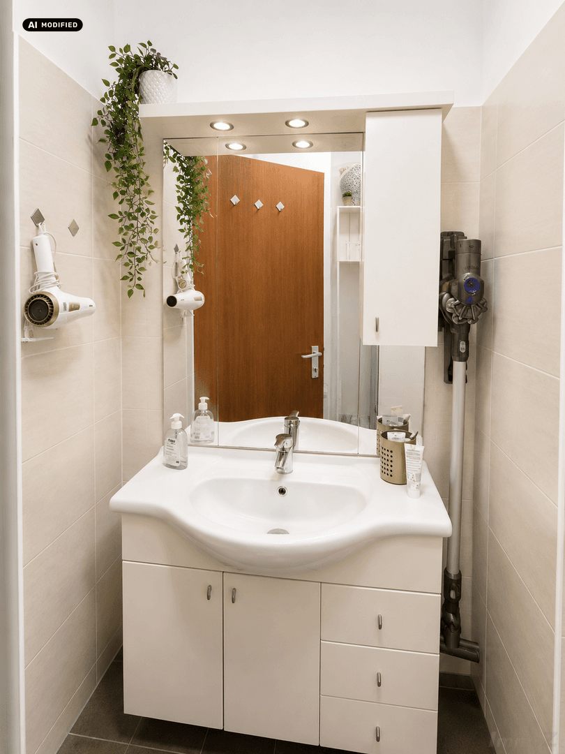 Badezimmer mit Waschbecken, Spiegelschrank und integrierter Beleuchtung.