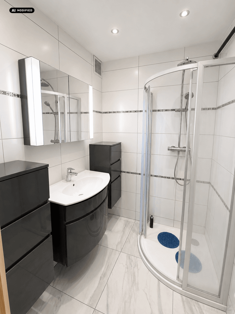 Modernes Badezimmer mit Eckdusche, weißen Fliesen und dunklem Waschtischunterschrank.