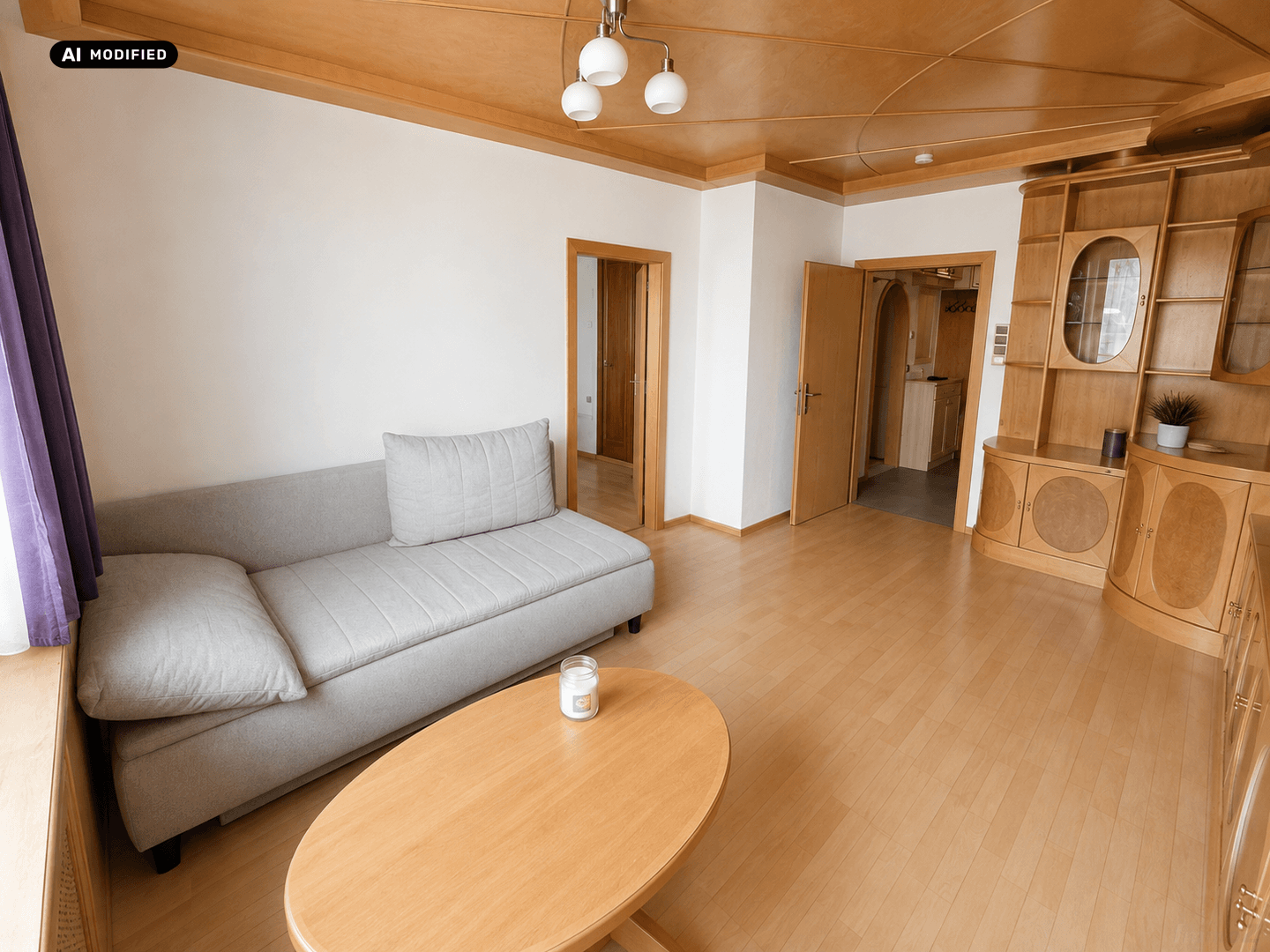 Gemütliches Wohnzimmer mit Sofa, Couchtisch und Blick auf die Holzschrankwand.