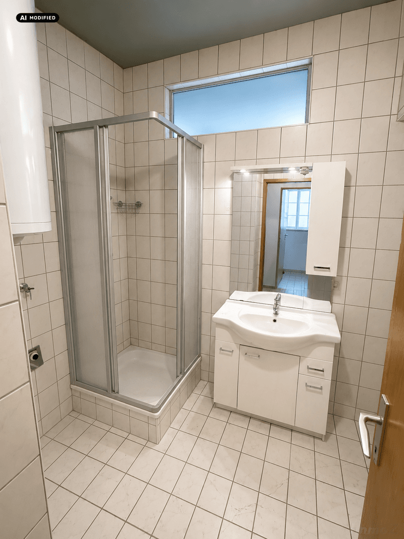 Funktionales Badezimmer mit Duschkabine, Waschbecken und Fliesen an Wänden und Boden.