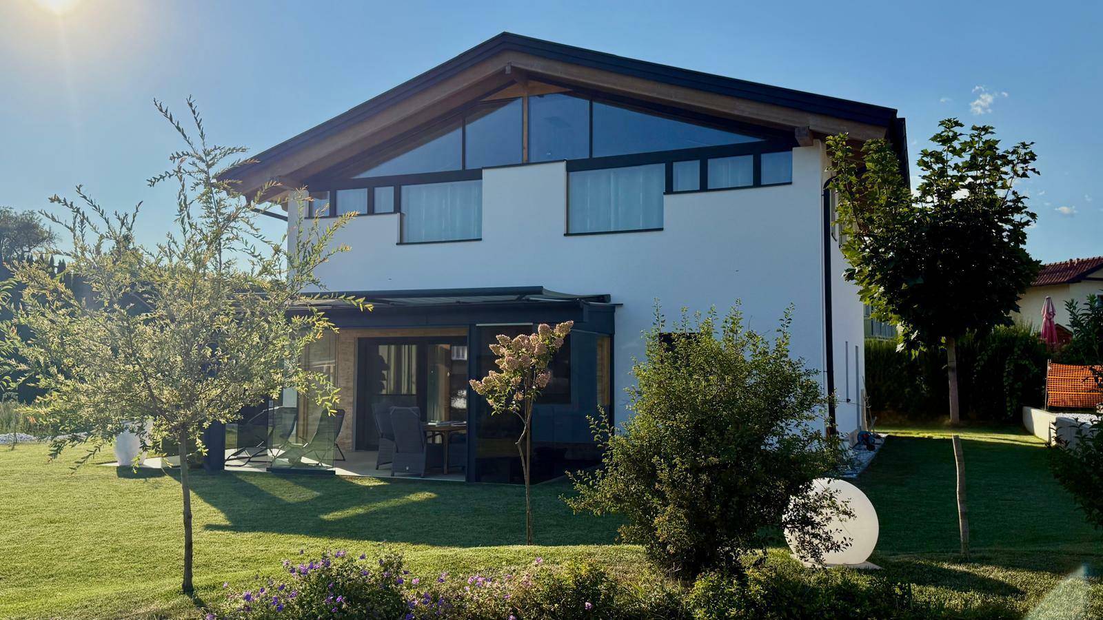 Sonniges Einfamilienhaus mit großem Garten, Terrasse und moderner Architektur.