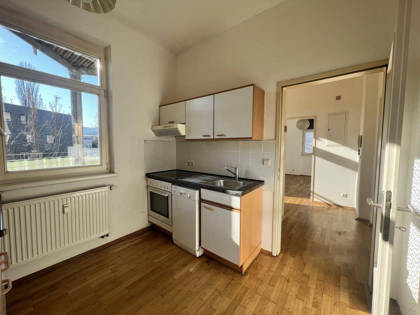 Funktionale Küche mit kleiner Einbauküche, Herd und Spüle, ideal für den täglichen Gebrauch.