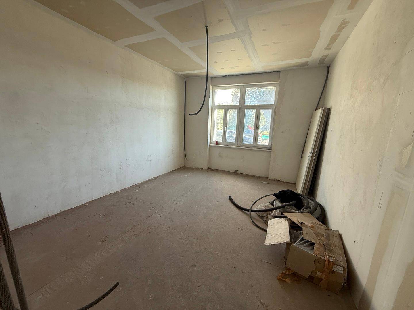 Raum im Rohbauzustand mit unfertigen Wänden und Decke, bereit für den weiteren Ausbau und die Gestaltung.