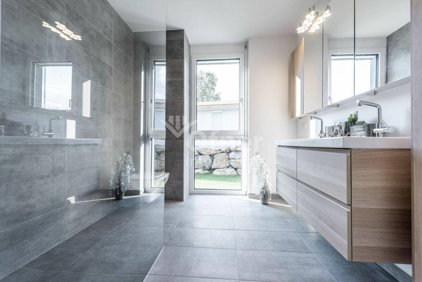 Modernes Badezimmer mit Doppelwaschbecken, großer begehbarer Dusche und Fenster.