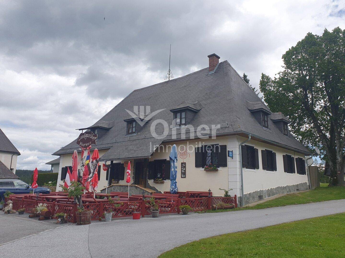 Seitenansicht des Landgasthofs mit traditioneller Architektur und einladender Außenterrasse.