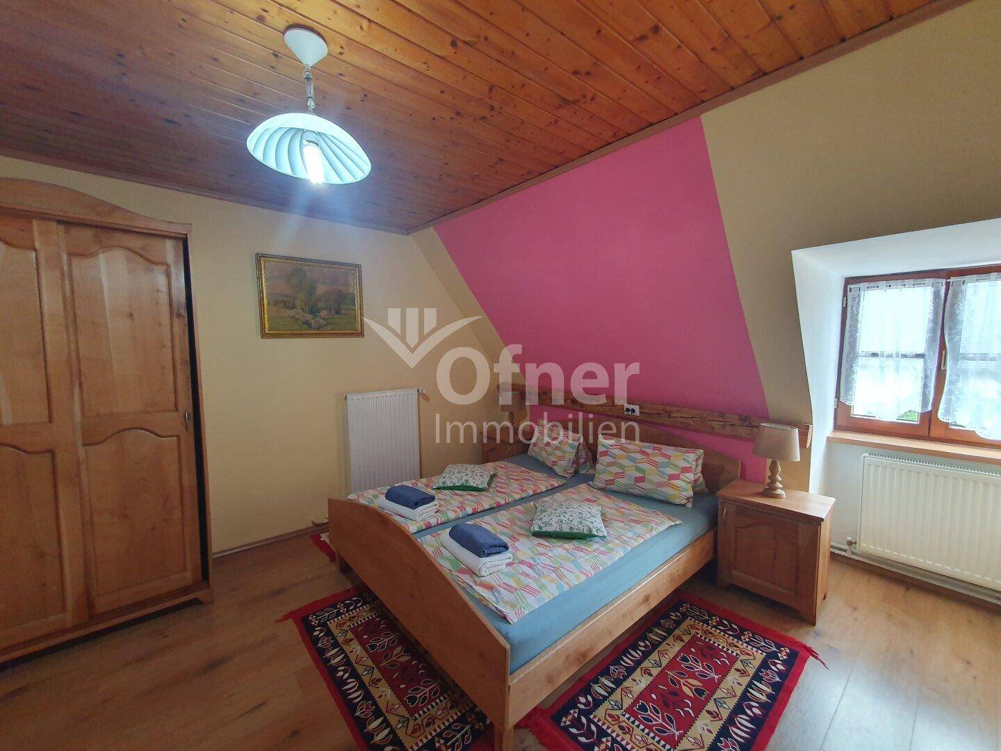 Rustikales Schlafzimmer mit Holzboden, Holzdecke und traditionellen Möbeln.