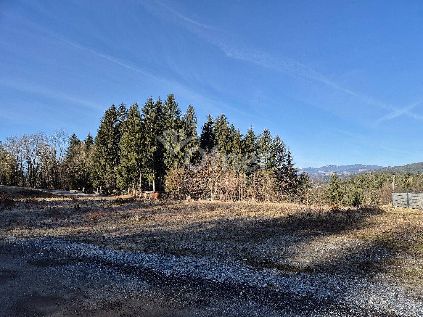 Offenes Grundstück mit weitem Blick auf die bewaldete Umgebung und die Berglandschaft.