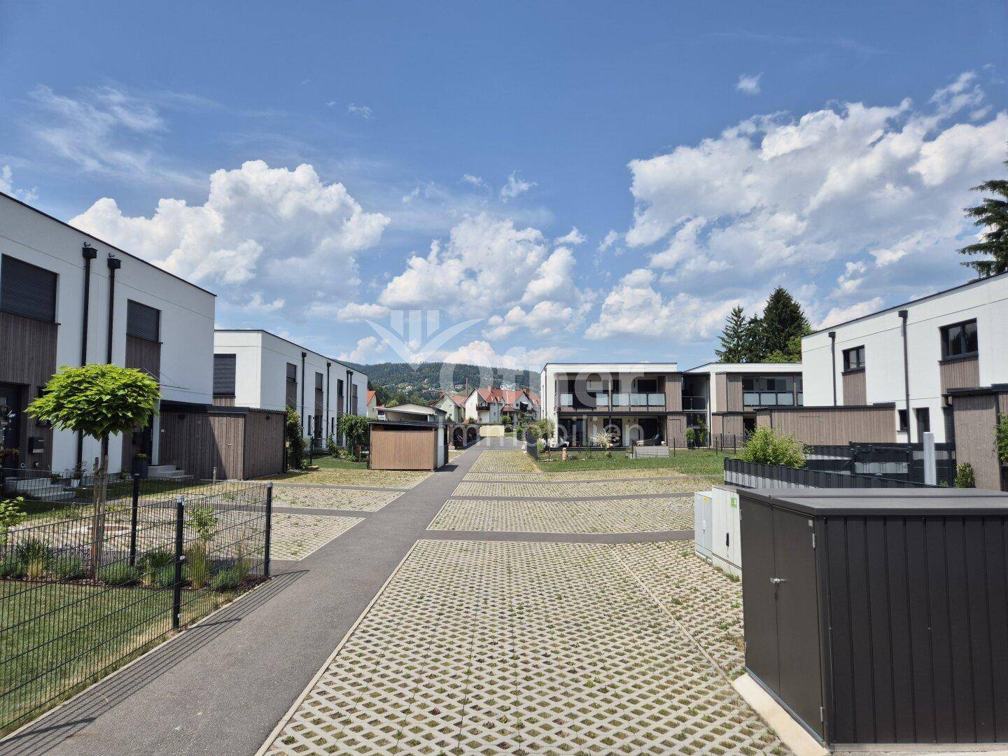 Überblick über die moderne Wohnanlage mit Reihenhäusern und Parkflächen in grüner Umgebung.