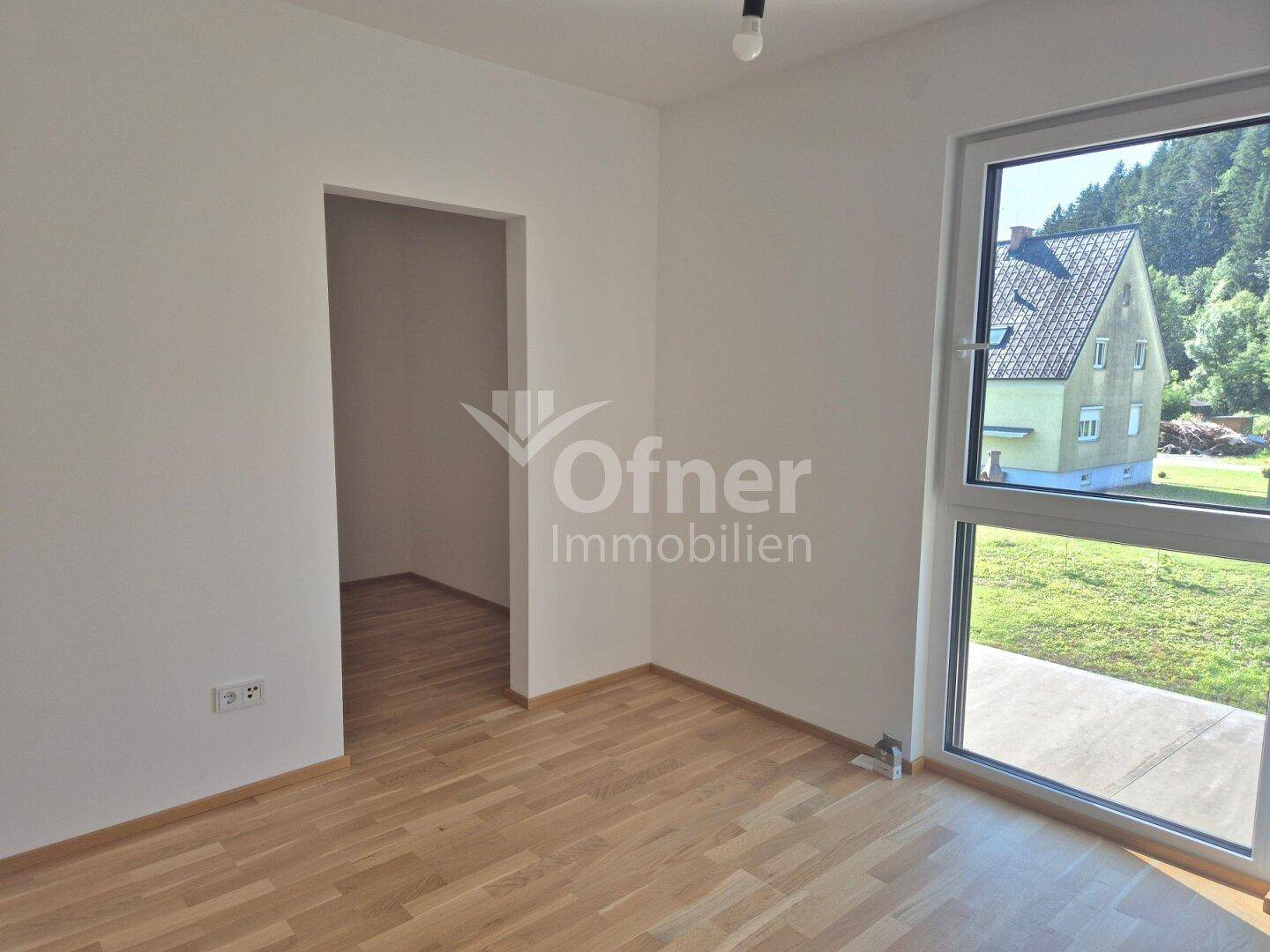 Heller Raum mit Parkettboden und großer Fensterfront, ideal als Schlaf- oder Arbeitszimmer.