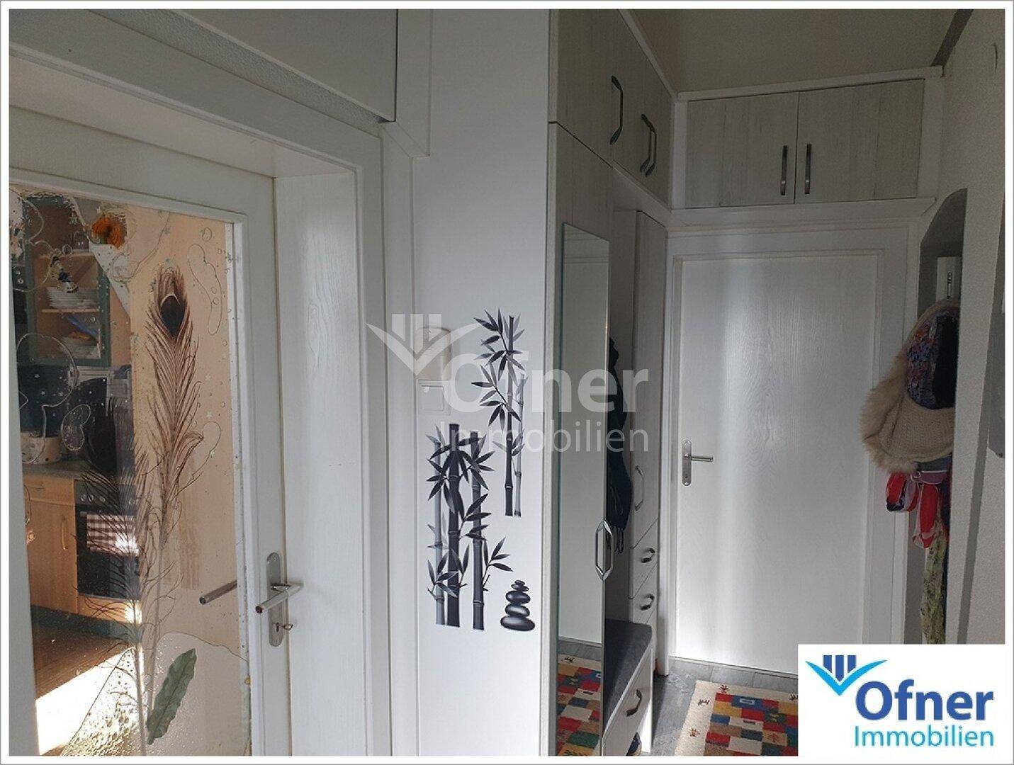Eingangsbereich mit Garderobe, Spiegel und dekorativen Wandstickern.