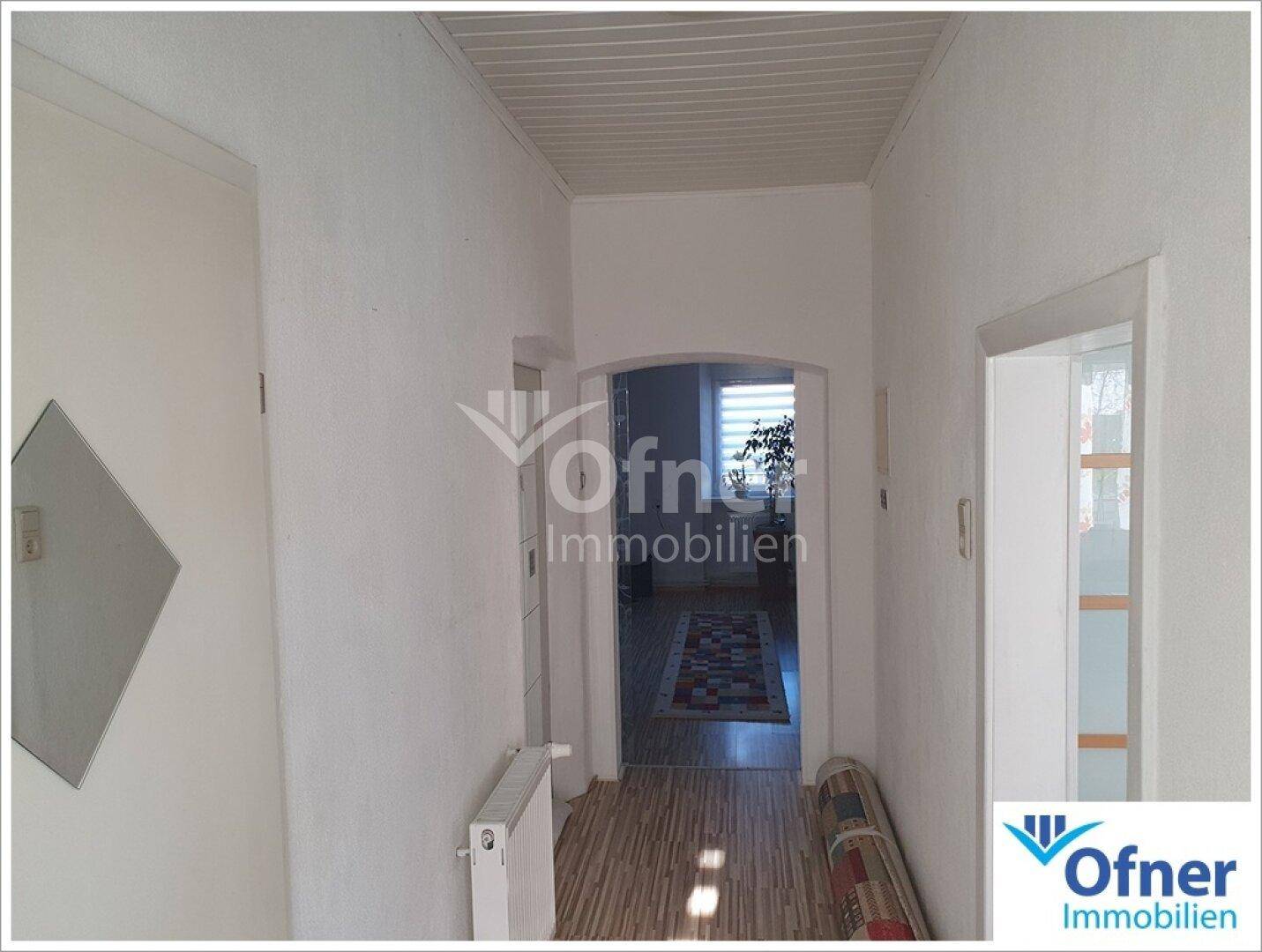 Heller Flur mit Holzdeckenverkleidung und Zugang zu weiteren Räumen.