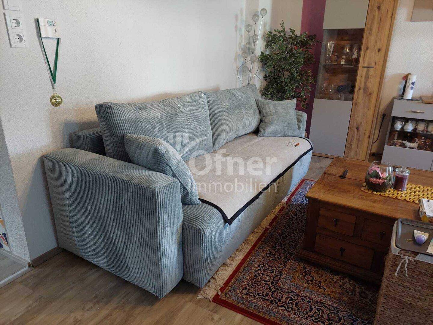 Gemütliches Wohnzimmer mit großem Sofa, Holztisch und Teppich.