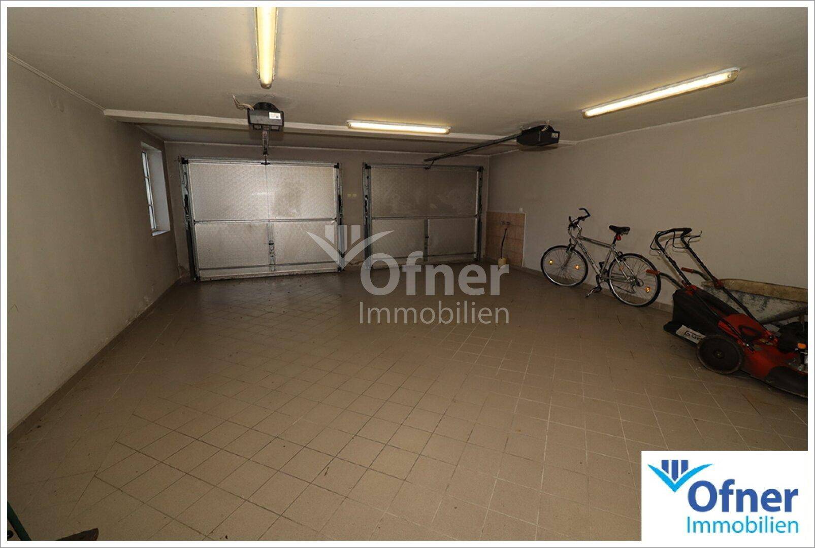 Geräumige Doppelgarage mit zwei Toren, Fliesenboden und ausreichend Platz.