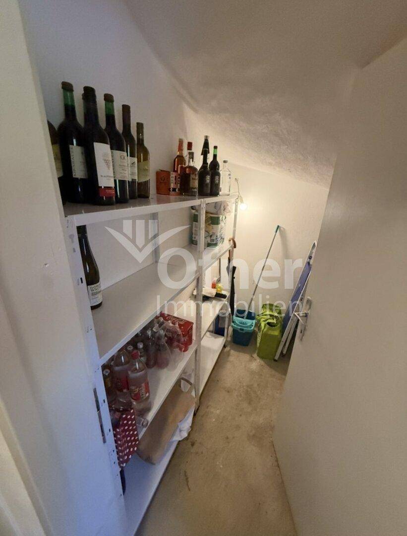 Praktischer Abstellraum mit Regalen für Vorräte und Weinflaschen, unter einer Dachschräge.