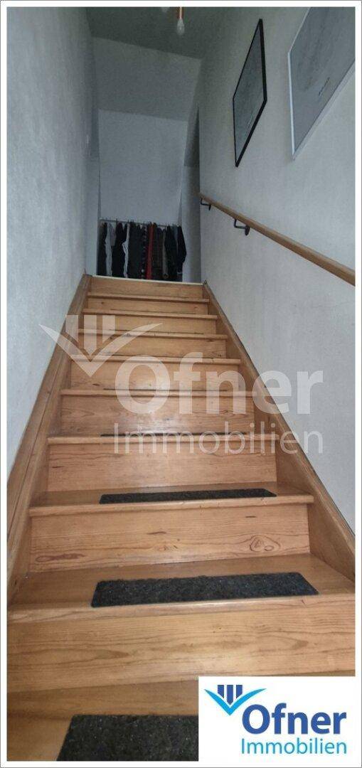 Robuste Holztreppe mit Handlauf, die in das obere Stockwerk des Hauses führt.