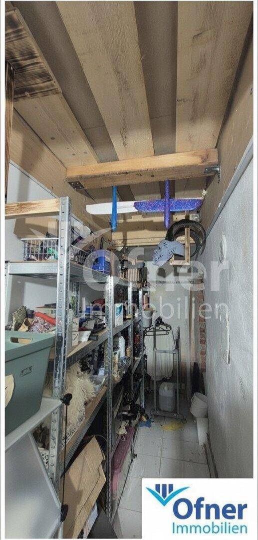 Kellerraum mit Regalsystemen und sichtbaren Holzbalken an der Decke, ideal als Lagerfläche.