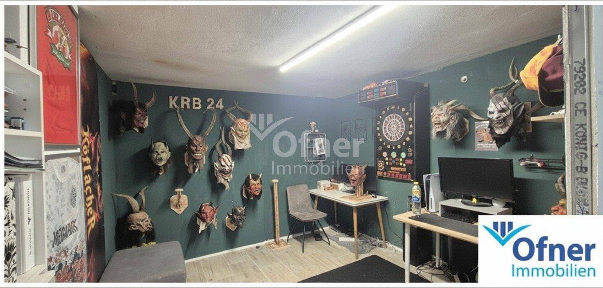 Farbenfroher Hobbyraum mit Dartscheibe, Schreibtisch und dekorativen Masken an der grünen Wand.