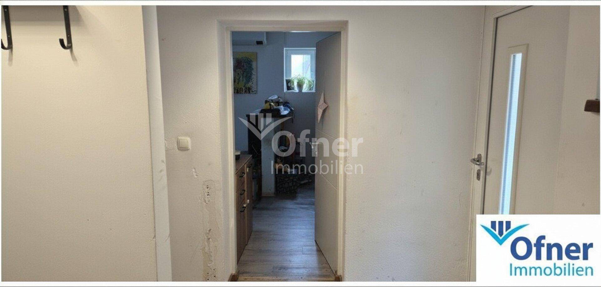Heller Flur mit Laminatboden und Zugang zu weiteren Räumen im Haus, mit natürlichem Lichteinfall.