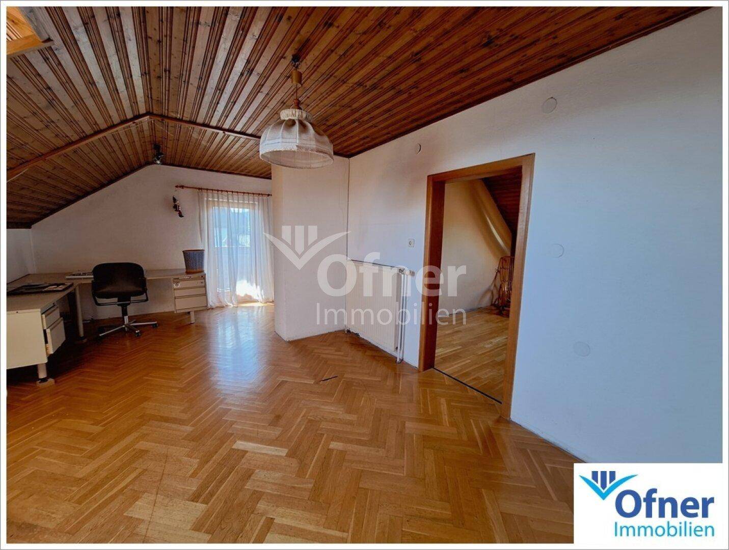 Helles Arbeitszimmer mit Parkettboden, Holzdecke und Dachschrägen.
