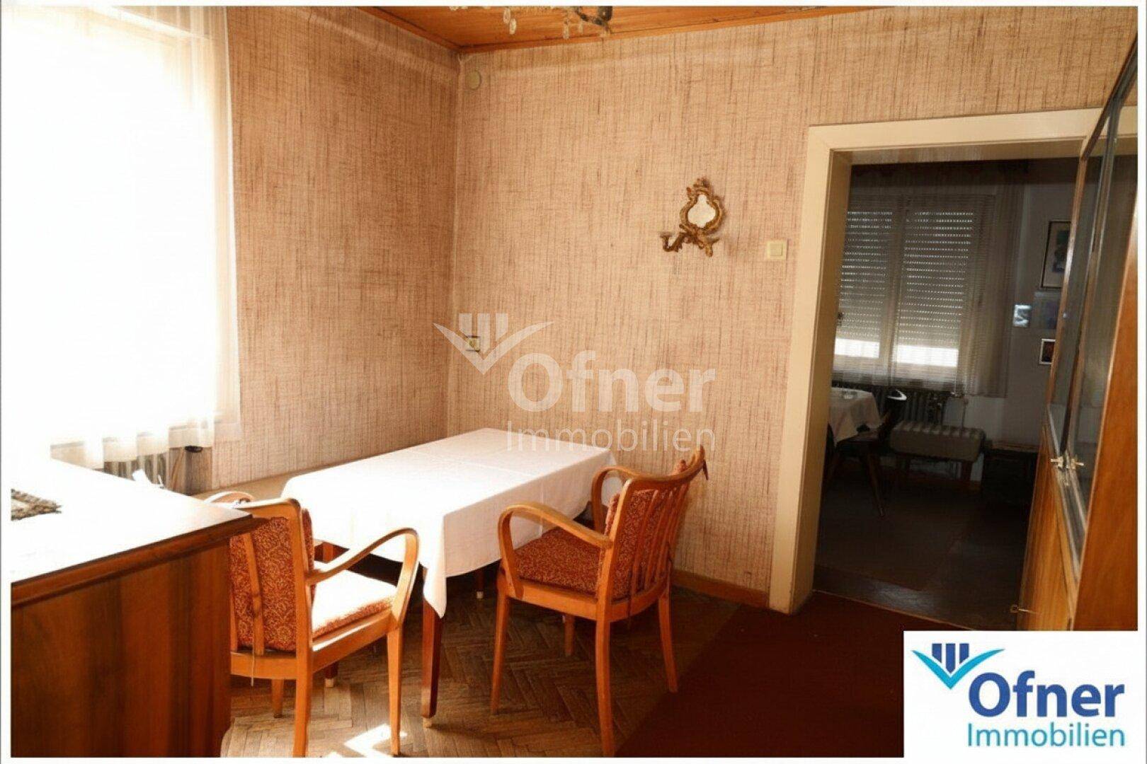 Kleiner Essbereich mit Holztisch, Stühlen und gemusterter Tapete in einem traditionellen Stil.