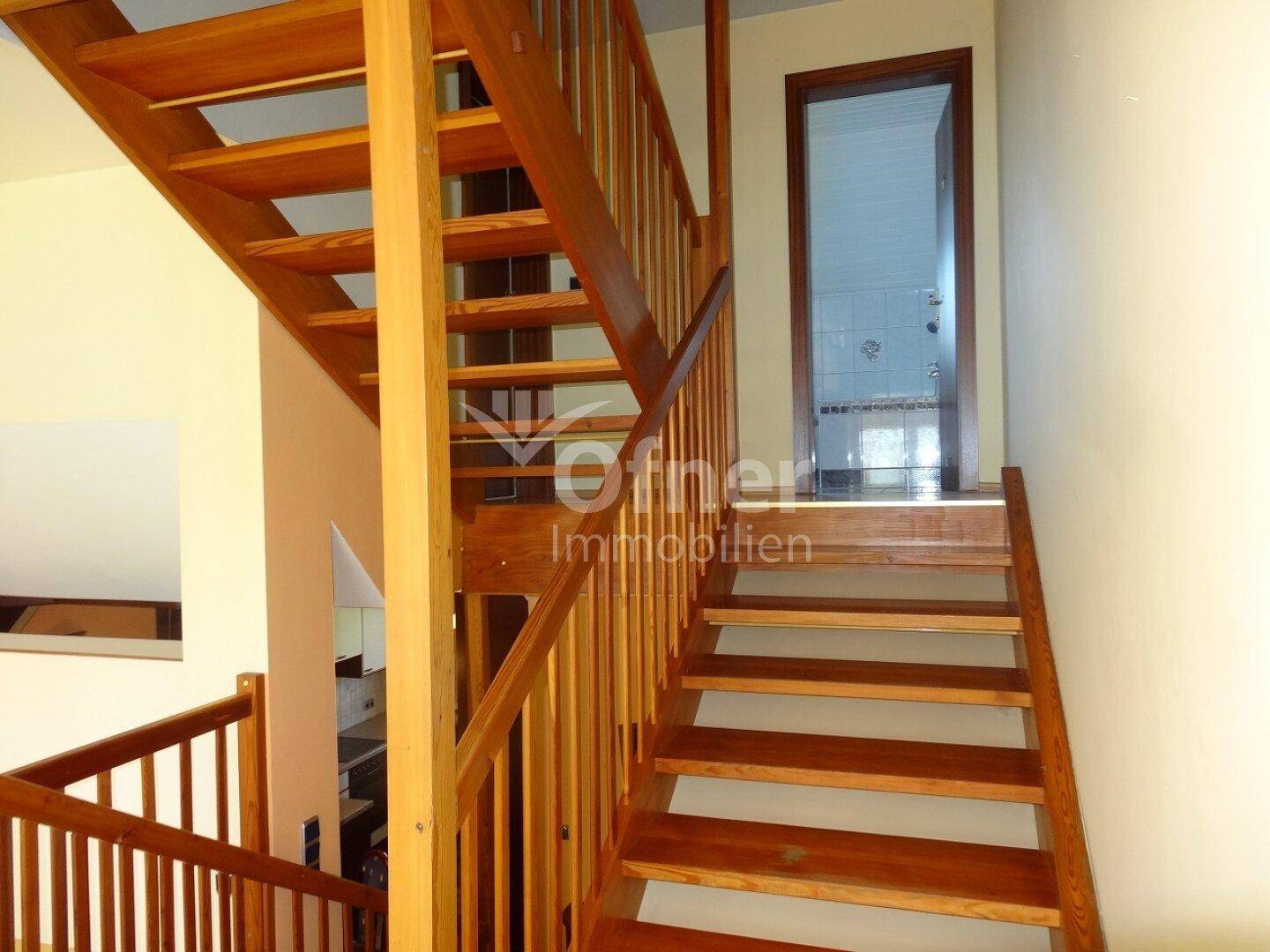 Holztreppe führt in die obere Etage, mit Blick auf ein Badezimmer.