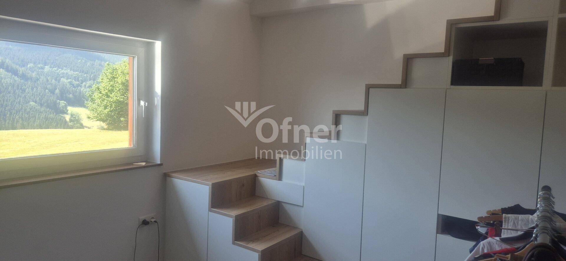 Kinderzimmer mit integrierten Schränken, Treppe und Fenster mit Bergblick.