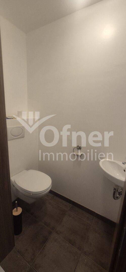 Kleines Gäste-WC mit Toilette und Waschbecken.