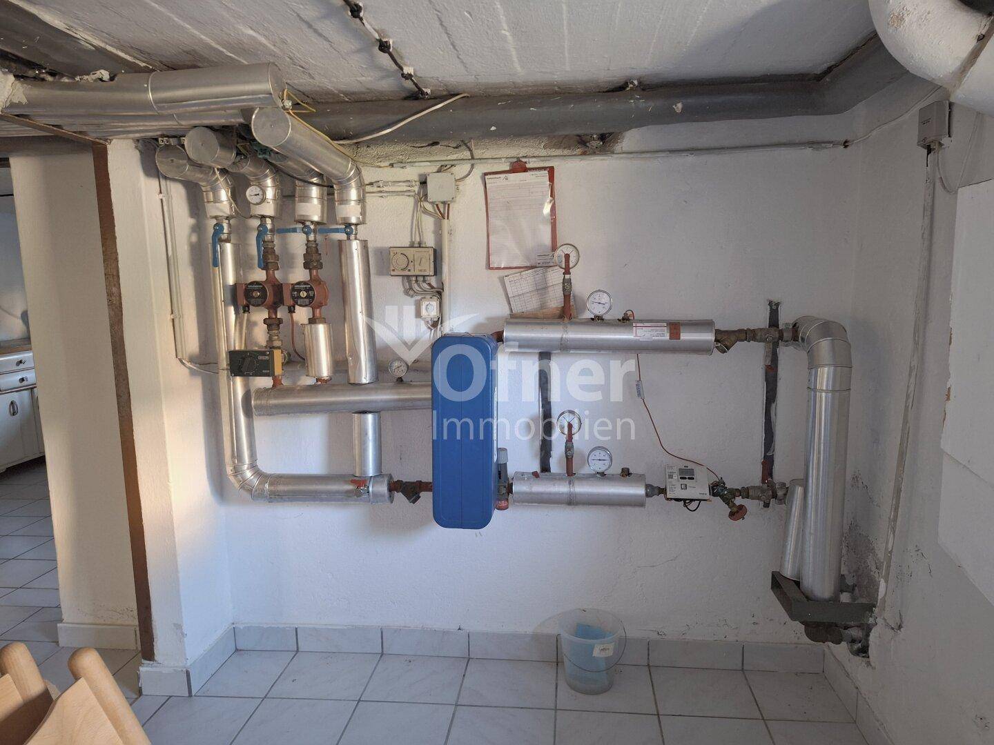 Heizungsraum mit zahlreichen Rohren und technischen Installationen für die Wärmeversorgung.