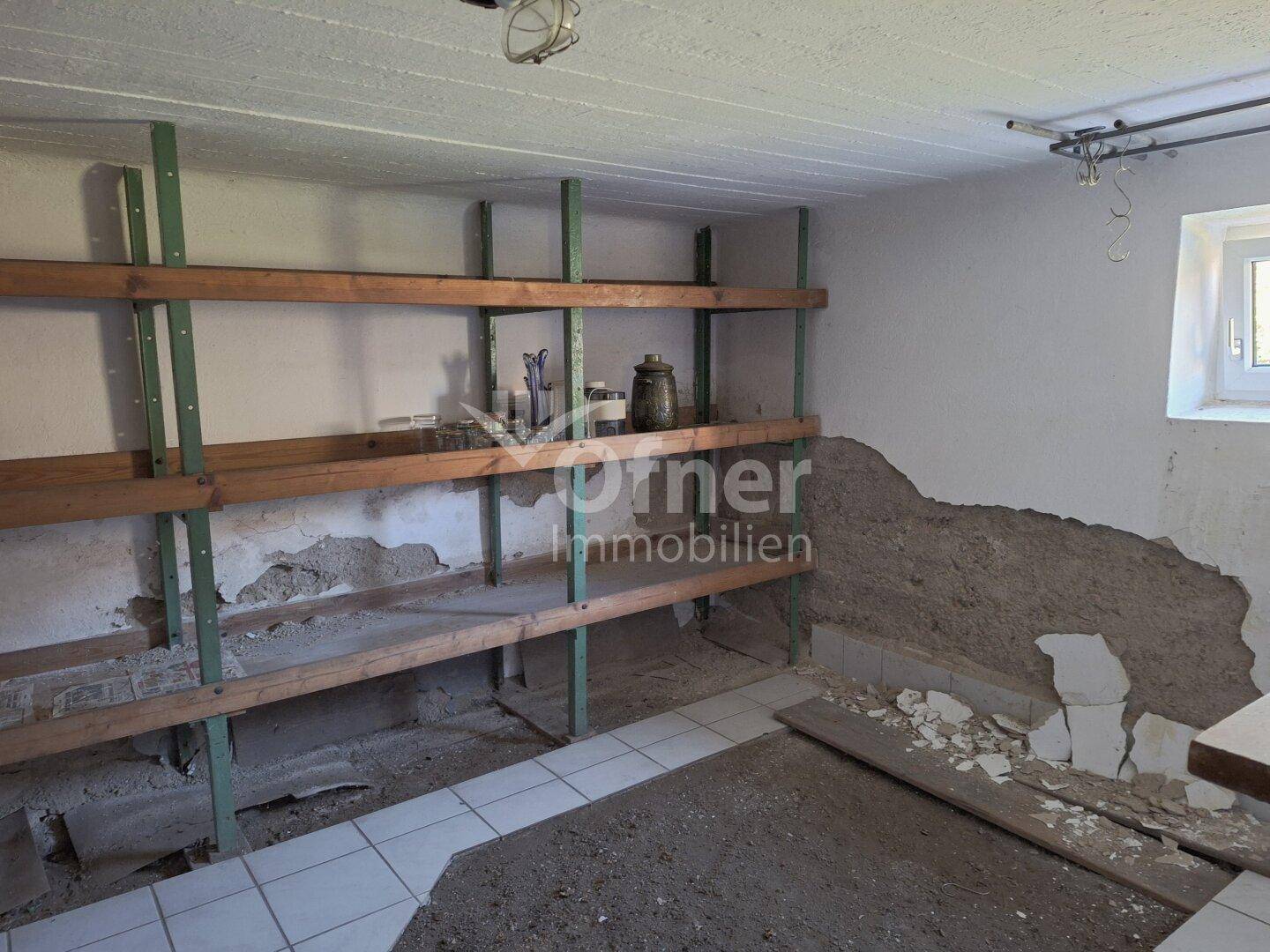 Lagerraum im Keller mit einfachen Holzregalen und unverputzten Wänden, ideal für Vorräte.