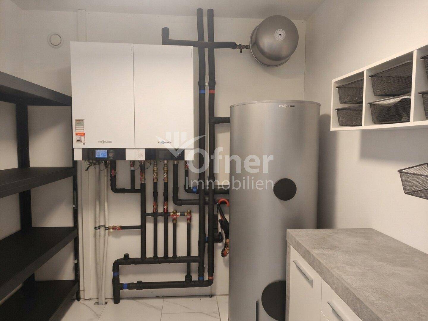 Technikraum mit moderner Heizungsanlage, Warmwasserspeicher und praktischen Regalen für Stauraum.