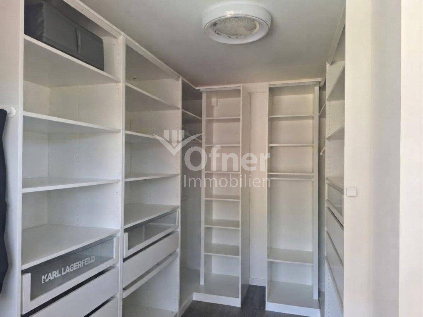 Geräumiger begehbarer Kleiderschrank mit vielen Regalen und Schubladen für optimale Organisation.