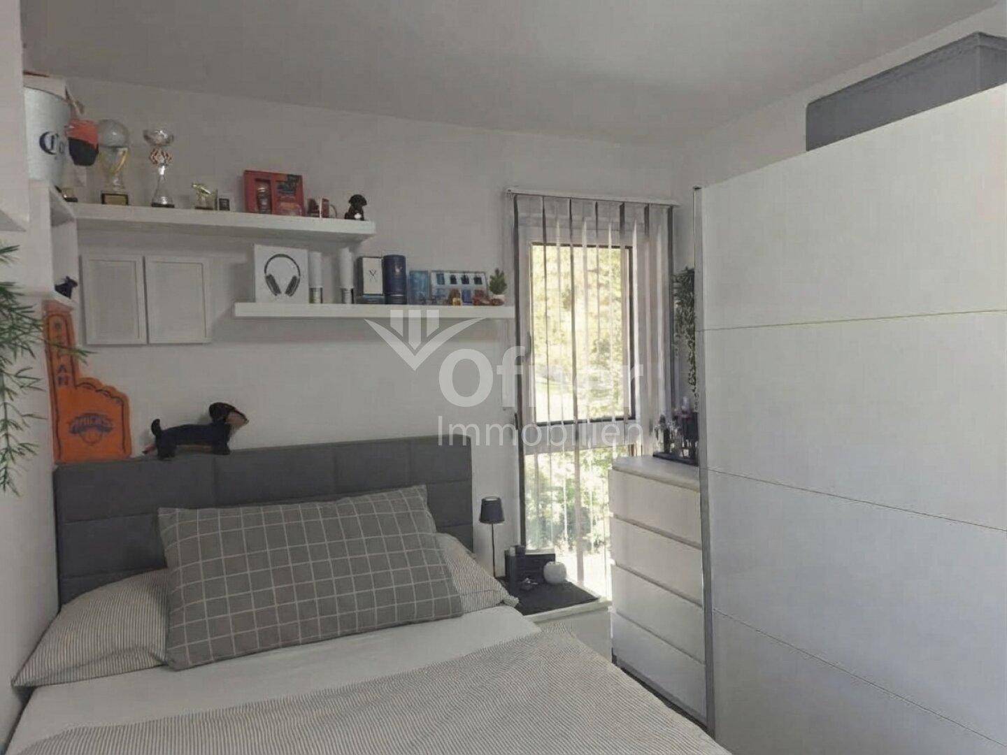 Kinderzimmer oder Gästezimmer mit Einzelbett, Schrank und Fenster mit Blick ins Freie.
