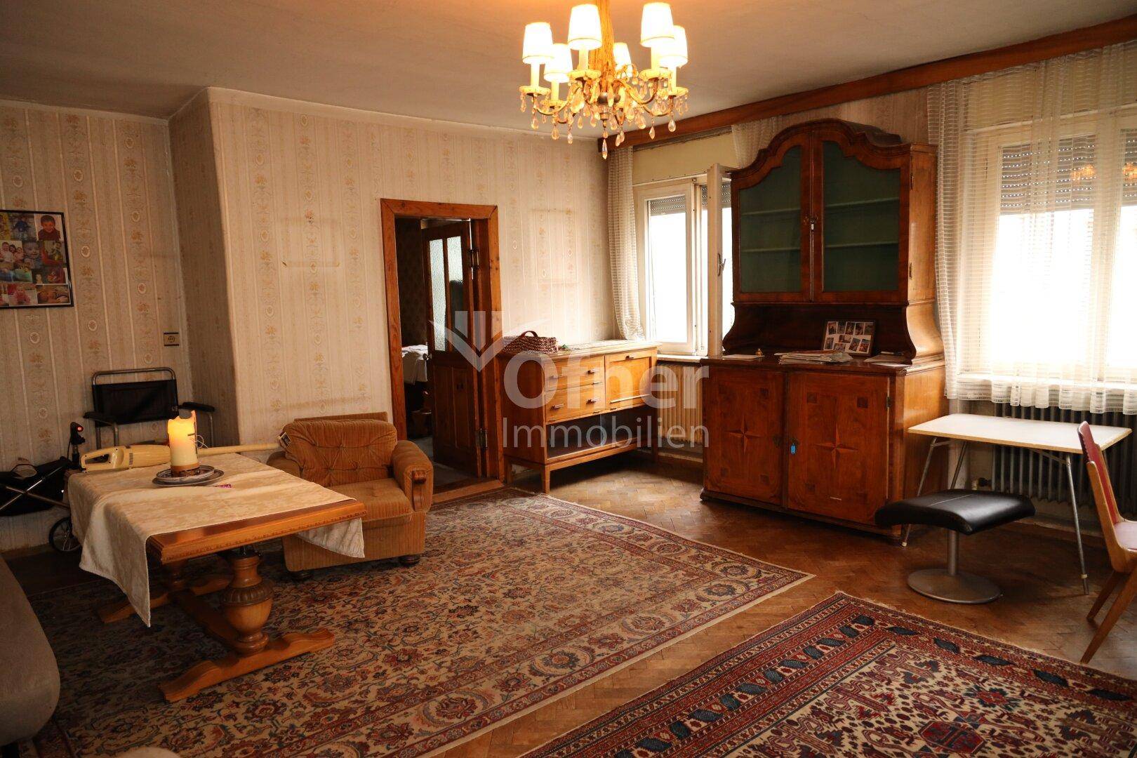 Gemütliches Wohnzimmer mit traditionellen Möbeln, Teppichen und Kronleuchter.