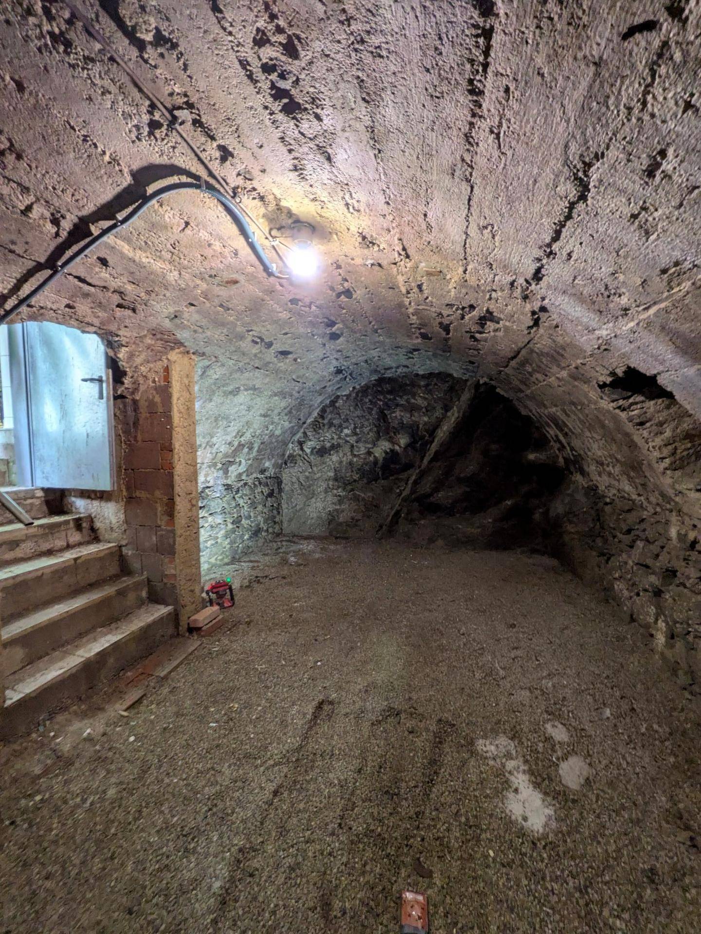 Historischer Gewölbekeller mit rustikalen Steinwänden und Decke, ideal als Lagerraum.
