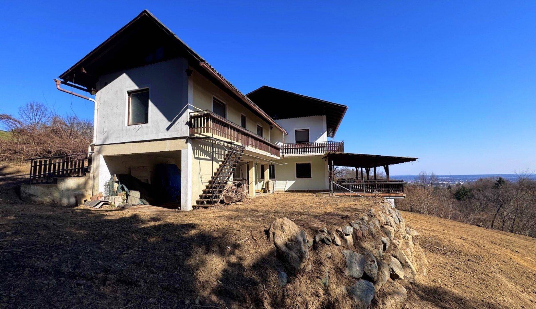 Das Haus auf einem sonnigen Hanggrundstück mit mehreren Balkonen und Terrassen.