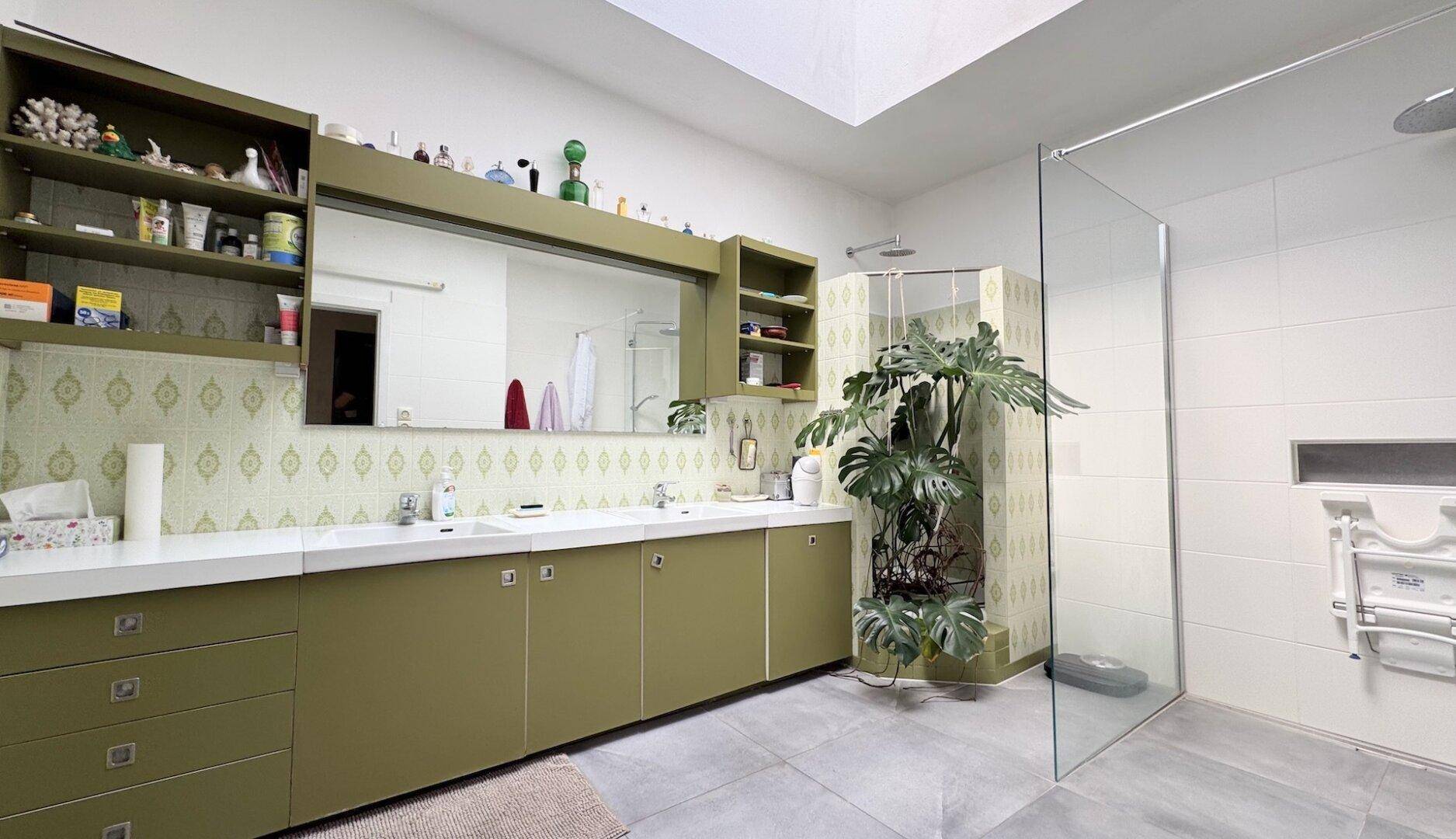 Modernes Badezimmer mit Doppelwaschbecken, großer Dusche und Oberlicht.