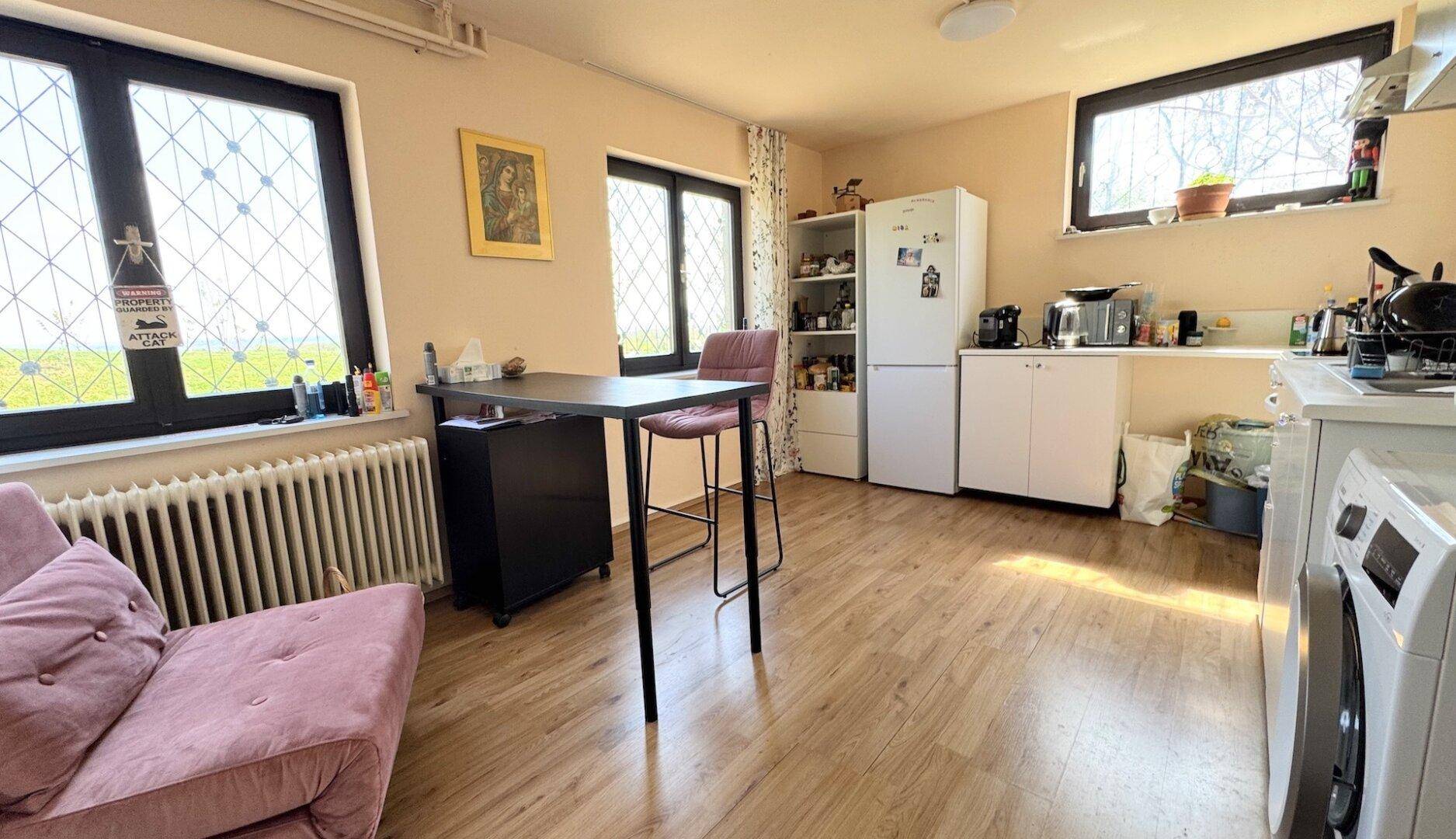 Funktionale Küche mit Laminatboden, Kühlschrank und Waschmaschine.
