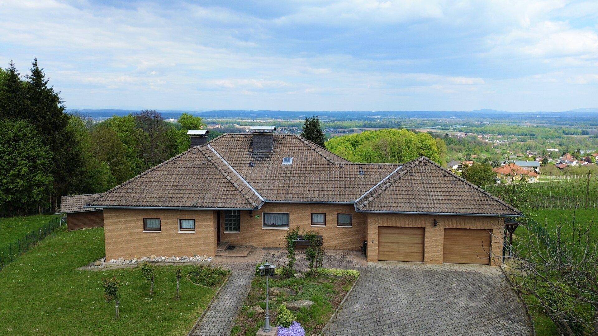 Vorderansicht des Hauses mit gepflasterter Auffahrt und weitem Blick über die Landschaft.