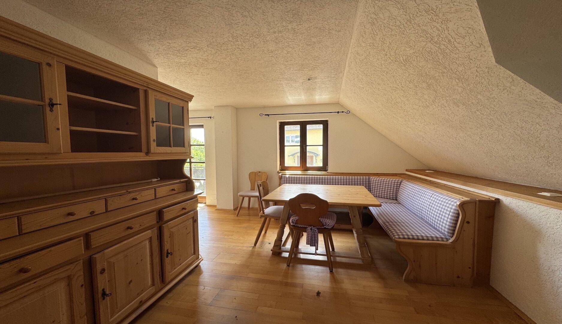 Gemütlicher Essbereich im Dachgeschoss mit Holztisch, Eckbank und Dachschräge.