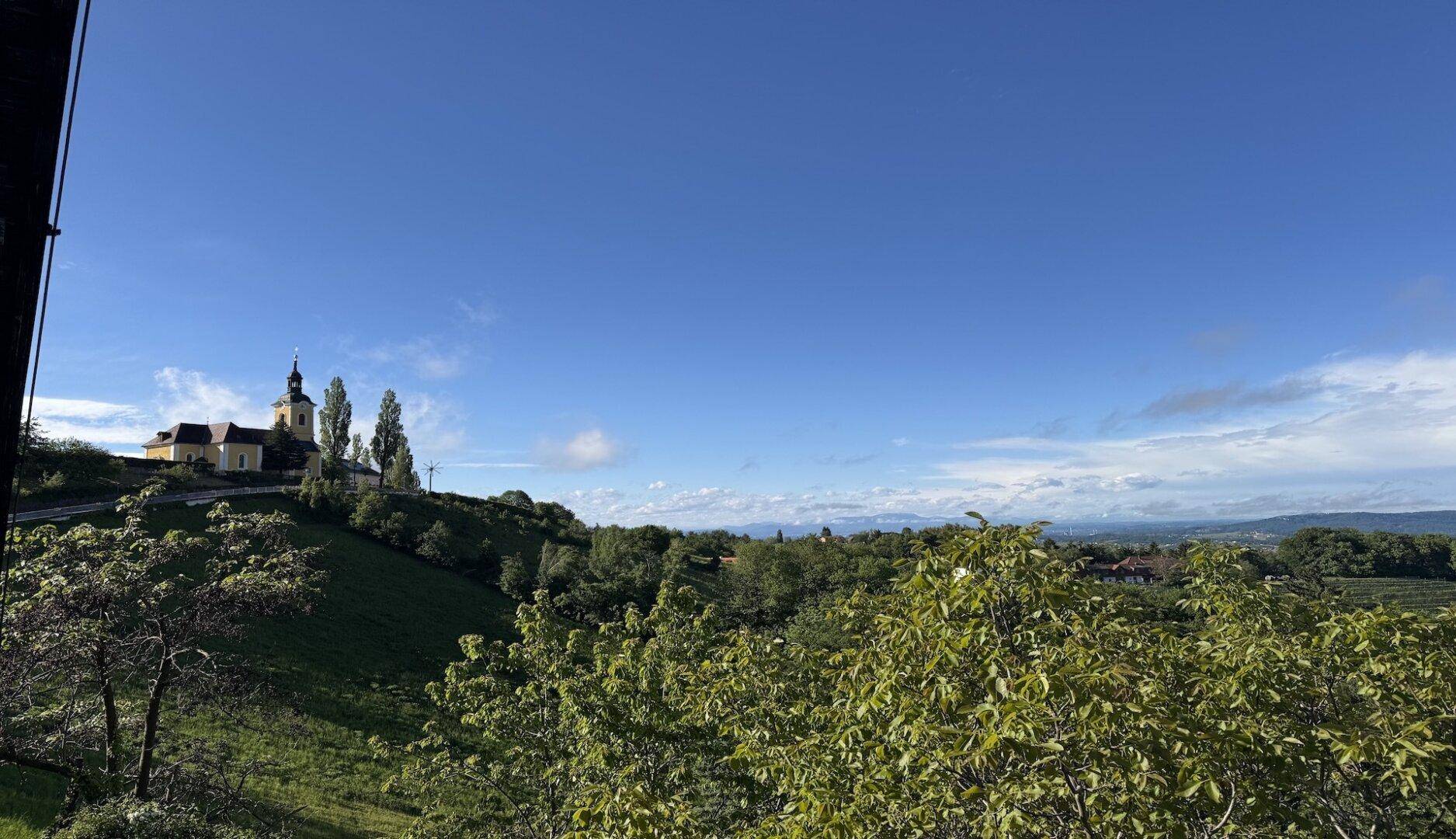 Weitblick auf die malerische Kirche auf dem Hügel unter strahlend blauem Himmel.