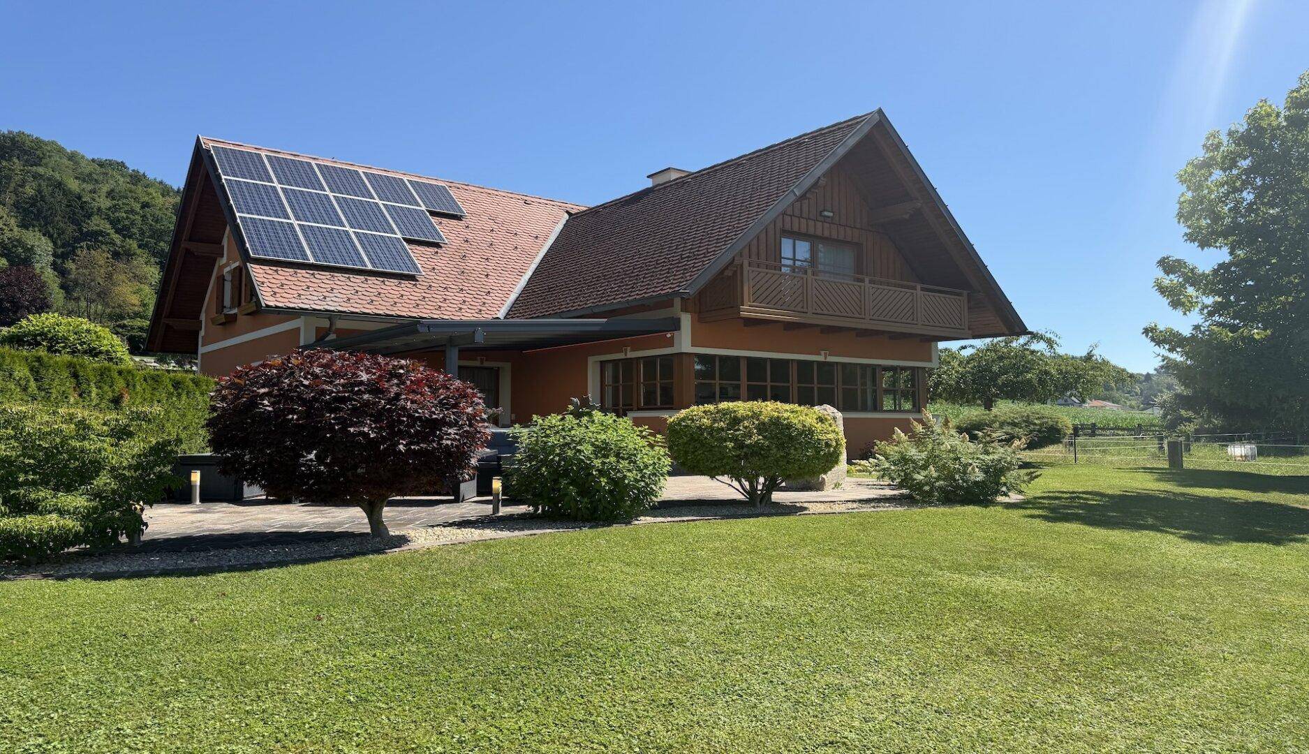 Gepflegter Gartenbereich mit Einfamilienhaus, Photovoltaikanlage und Terrasse.