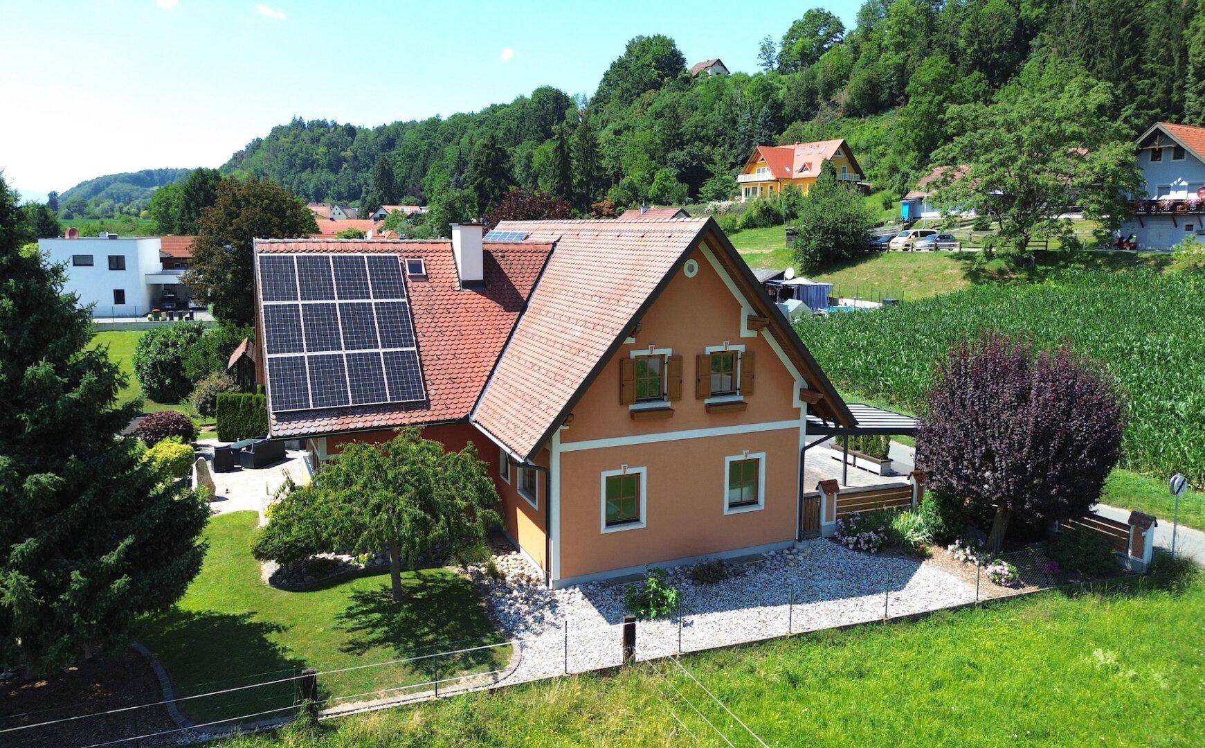 Seitenansicht des Einfamilienhauses mit Photovoltaikanlage und gepflegtem Vorgarten.