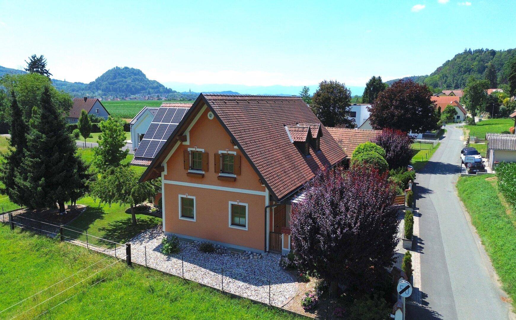 Rückansicht des Hauses mit Photovoltaikanlage und Blick auf die ländliche Umgebung.