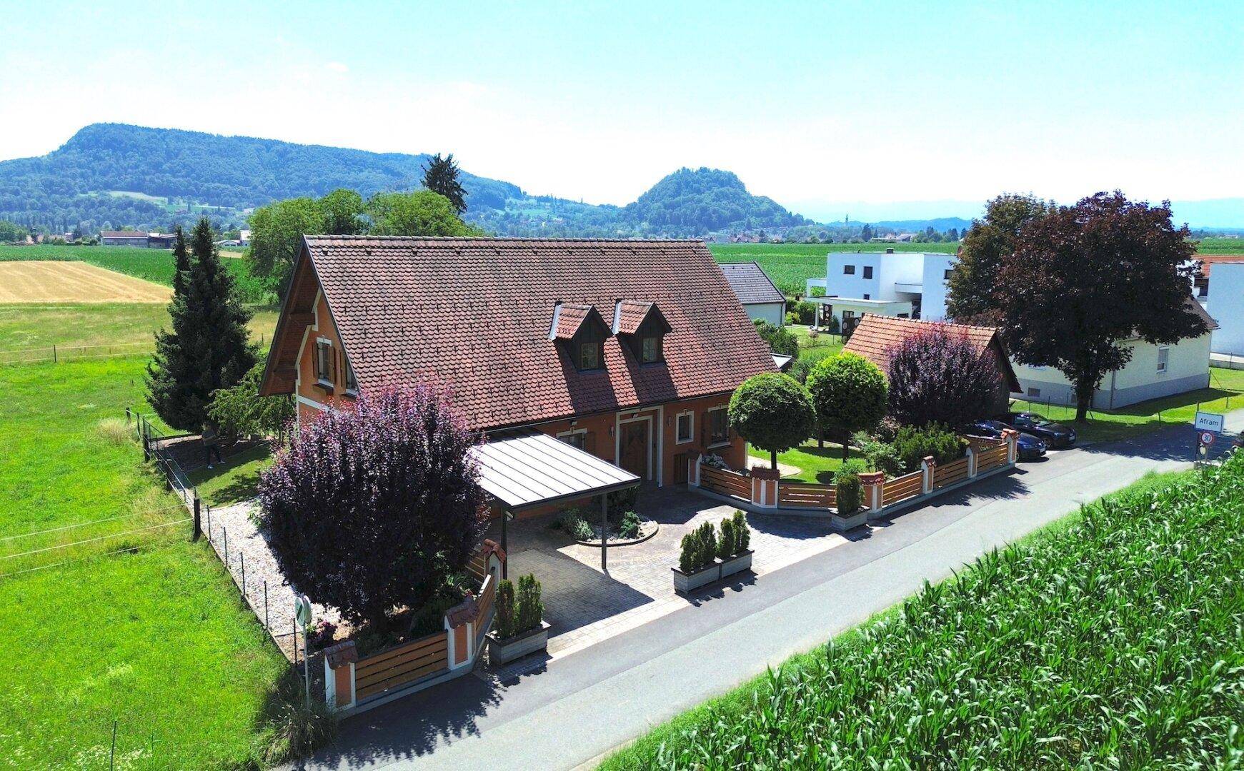 Luftaufnahme des Anwesens mit Haus, Carport und Zufahrt in ländlicher Umgebung.