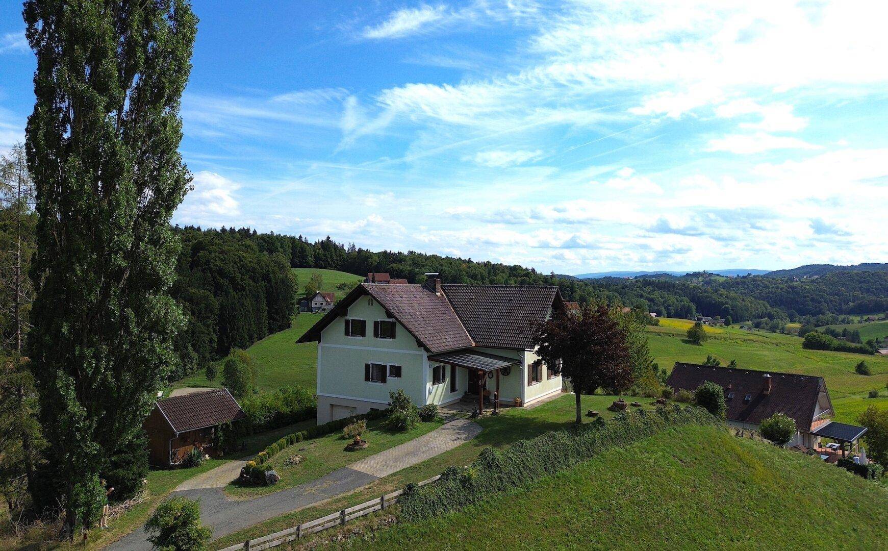 Wohnhaus mit traditionellem Satteldach und grüner Umgebung, ideal für Naturliebhaber.