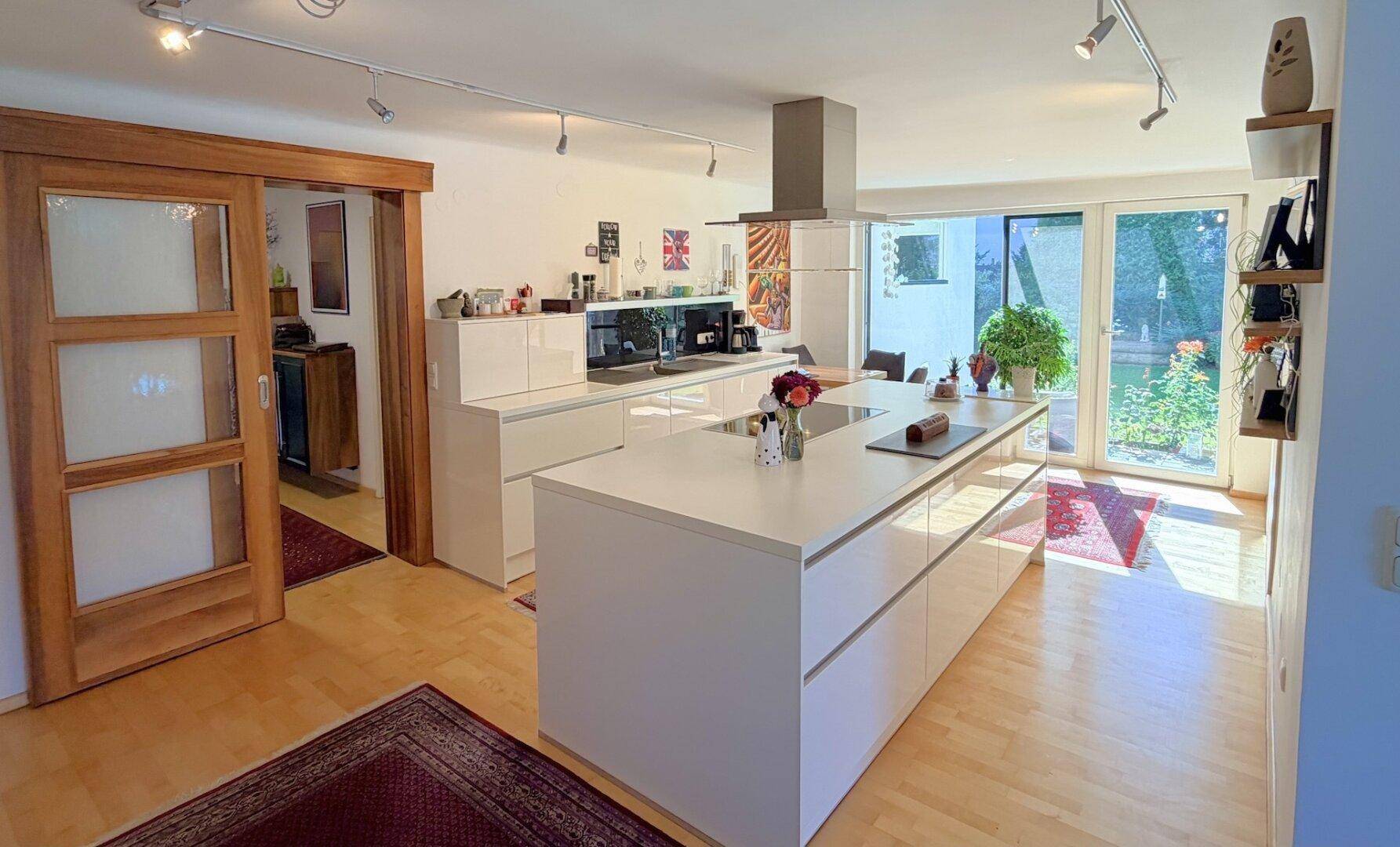 Moderne, offene Küche mit großer Kochinsel und hellem Holzfußboden.