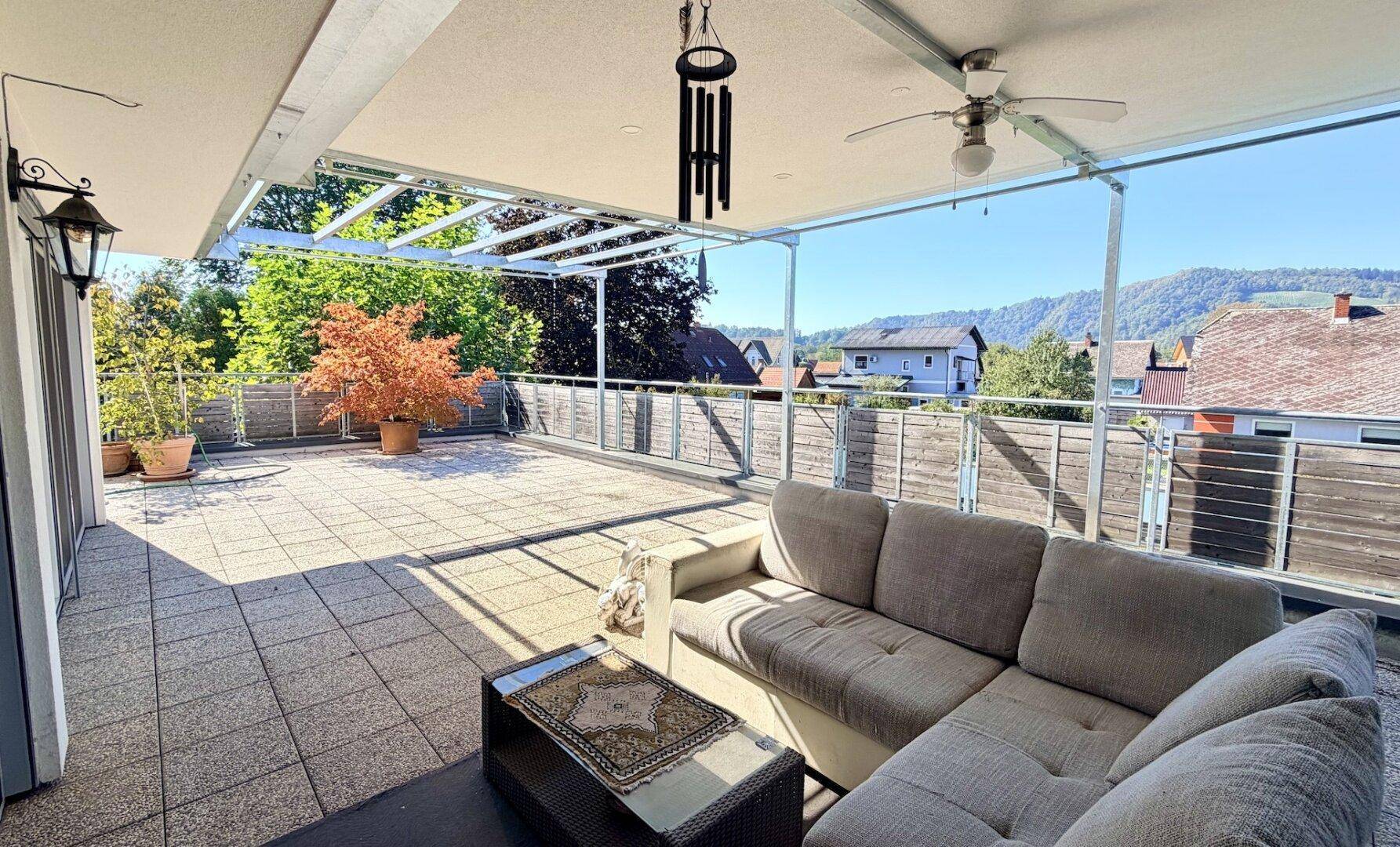 Große Dachterrasse mit Lounge-Möbeln und weitem Blick über die Umgebung.