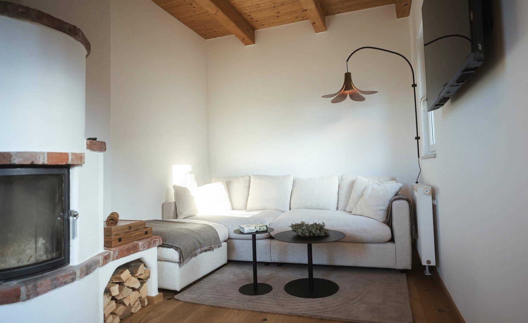 Heller Wohnbereich mit bequemem Ecksofa, modernem Kamin und Holzbalkendecke.